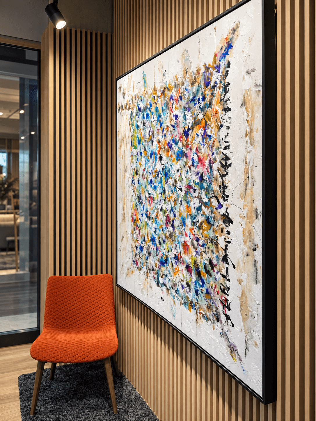 Obraz abstrakcyjny i pomarańczowe krzesło w salonie Abar Interior Art w Domotece